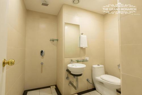 a bathroom with a toilet and a sink at The Grand Monarch Hotel, Ujjain in Ujjain