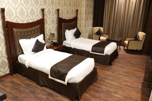 Pokój hotelowy z 2 łóżkami i krzesłem w obiekcie VRC CITY HEART w mieście Bathinda