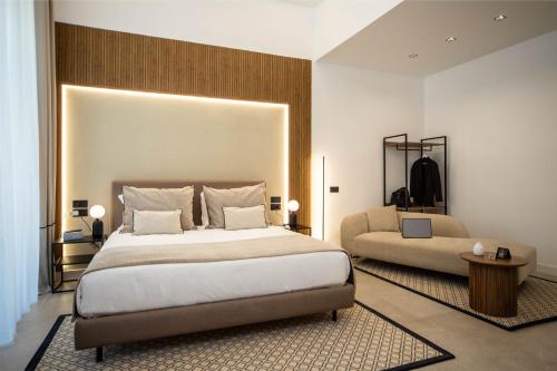 a bedroom with a large bed and a couch at MAMALU - Studios and Suites in Naples
