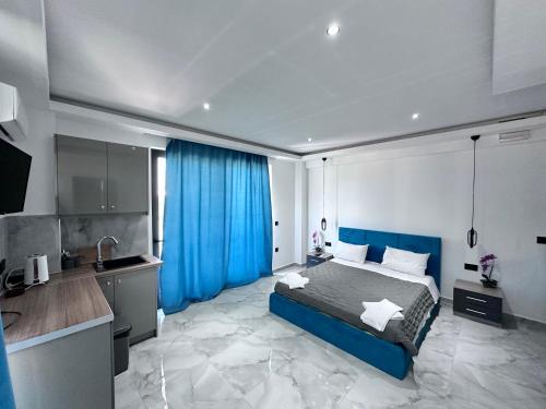 a bedroom with a blue bed and a kitchen at Central studios apartments in Alikanas