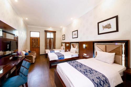 Habitación de hotel con 2 camas y escritorio en NIWA CANTING en Brumbung