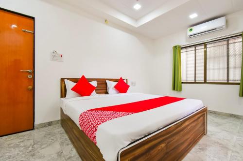 a bedroom with a large bed with red pillows at OYO Hotel Boss Lodging in Aurangabad