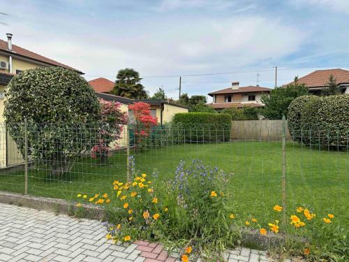 a garden with a fence and flowers in a yard at CASA DA PINA in ricordo della mia cara mamma in Angera