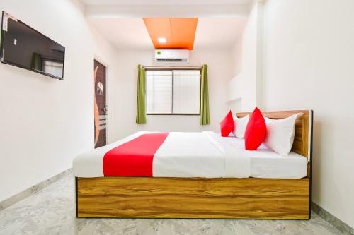 a bedroom with a large bed with red pillows at OYO Hotel Boss Lodging in Aurangabad