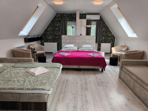 - une chambre avec deux lits et un canapé dans l'établissement Natura Panzió Szilvásvárad, à Szilvásvárad