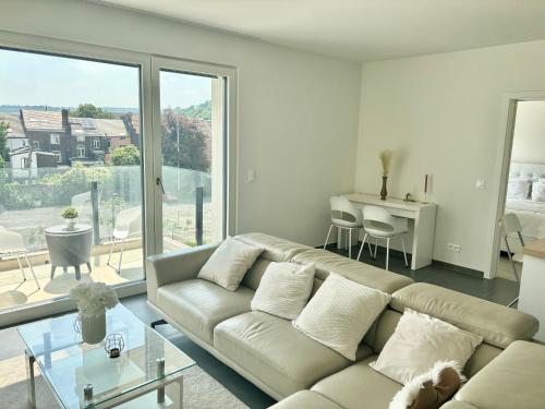 sala de estar con sofá y mesa en Paradis Express - Guillemins Luxury apartment en Lieja