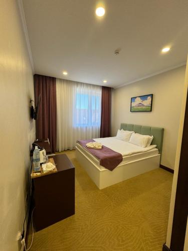 a hotel room with a bed and a table at SULO Atyrau Hotel in Atyraū