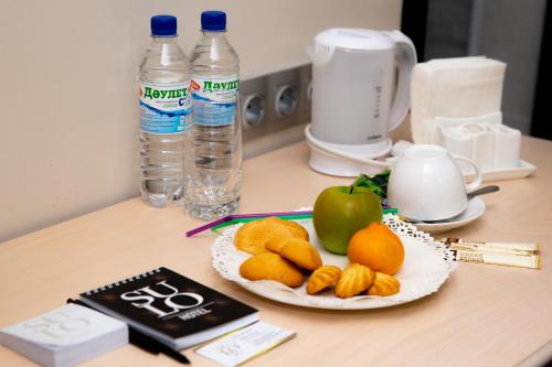 a plate of fruit and an apple on a counter at SULO Atyrau Hotel in Atyraū