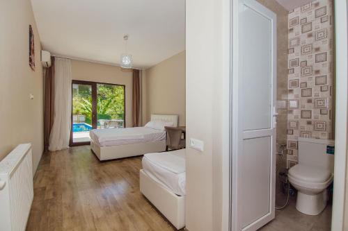 1 dormitorio con 1 cama y aseo en una habitación en Villa Lile en Batumi