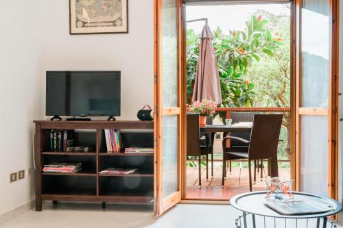 a living room with a television and a table at Stella Maris Holidays in Porto Conte