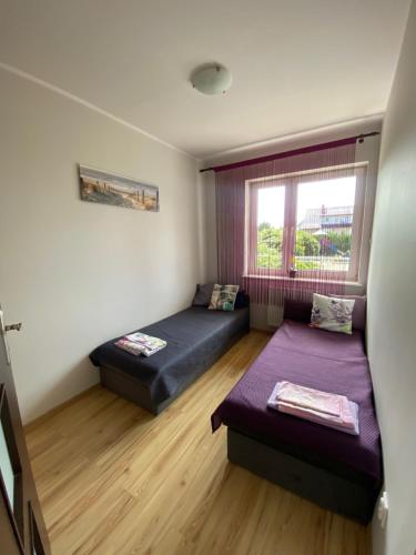 a room with two beds and a window at Apartament Klaudia in Stegna