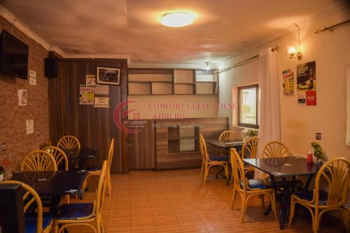 ein Esszimmer mit Tischen und Stühlen sowie ein Restaurant in der Unterkunft Happy Springs Hotel & Accomodation in Kericho