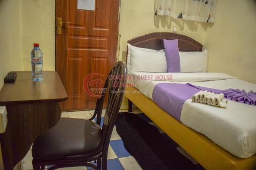 a bedroom with a bed and a desk and a chair at Happy Springs Hotel & Accomodation in Kericho