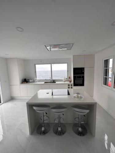 a kitchen with a island with two bar stools at Furna Blue View in Lagoa