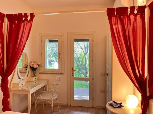 a room with a desk and red curtains at Splendida villa unifamiliare Posada in Torpè