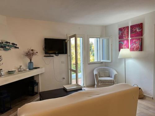 a living room with a bed and a tv at Splendida villa unifamiliare Posada in Torpè