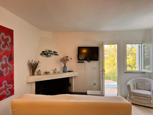 a bedroom with a bed and a fireplace and a tv at Splendida villa unifamiliare Posada in Torpè