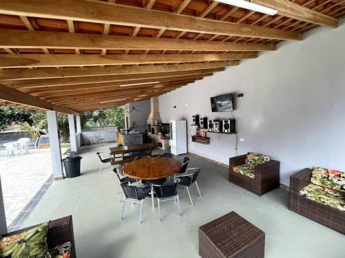 d'une terrasse avec une table et des chaises en bois. dans l'établissement Chácara piscinas incríveis, próximo a são paulo., à Mairinque