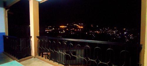 a balcony with a view of a city at night at Hotel Orchid in Kalimpong