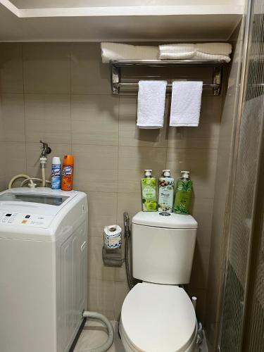 a bathroom with a toilet and a washing machine at 1br Shore Residences Staycation at Royels Place in Manila