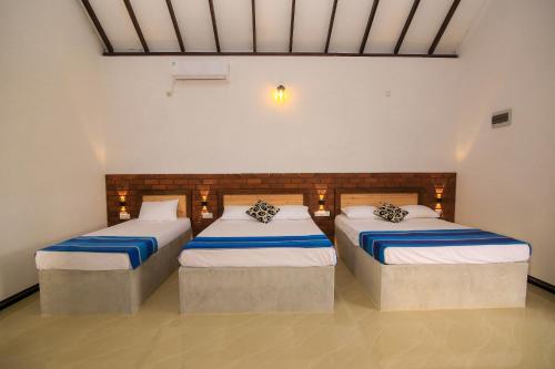 a room with two beds in a room at Ari Guest House in Anuradhapura