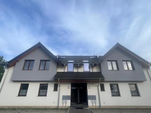a white house with a black roof at Apartamenty Parkowe in Łęknica