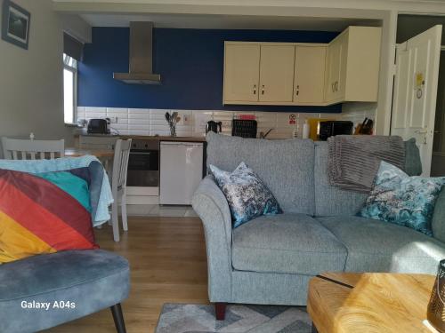 a living room with a couch and a kitchen at Elmgrove Apartment , Croagh Patrick Westport in Westport
