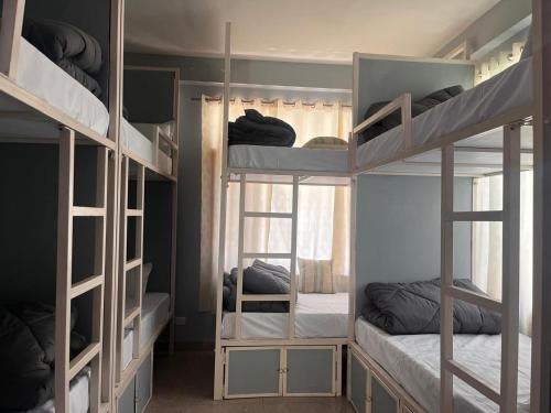 a room with three bunk beds and a window at Madpackers Kasol Riverside - Katagla in Kasol