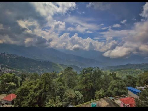 a view of a valley with mountains and trees at HOTEL RATNA in Darjeeling