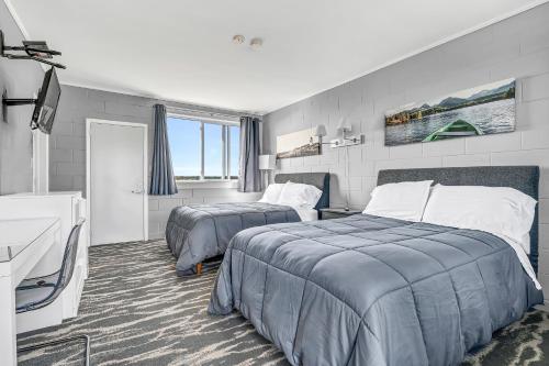 Habitación de hotel con 2 camas y escritorio en Cape View Motel & Cottages en Mavillette