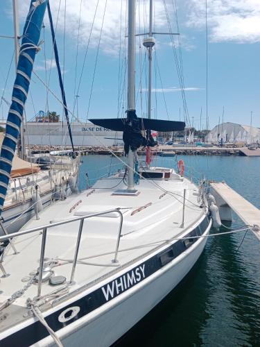 un velero blanco atracado en un muelle en el agua en Velero Valencia Whimsy en Valencia