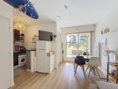 une cuisine et un salon avec une table et des chaises dans l'établissement V-Landes 04-Vieux Boucau Appartement 4 personnes dans résidence avec piscine au bord du lac marin, à Vieux-Boucau-les-Bains