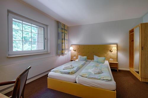 a bedroom with a large bed with a window at See Hotel Karlslust Chalets in Storkow