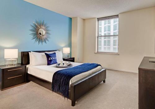 sypialnia z dużym łóżkiem z niebieską ścianą w obiekcie Beautiful Studio Apartment in NYC! w Nowym Jorku