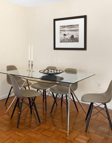 a dining room with a glass table and chairs at Beautiful Studio Apartment in NYC! in New York