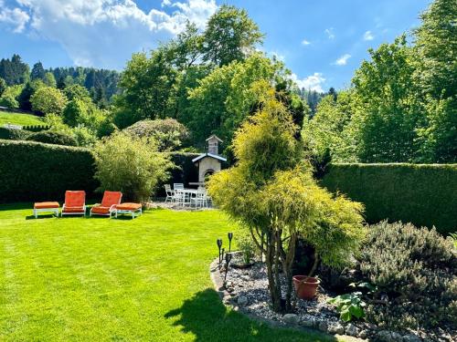 a garden with two chairs and a table in the grass at Chlösterli in Luzern