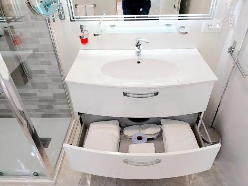 a white bathroom with a sink and towels at Villa Bellavista Alba, B&B in Alba