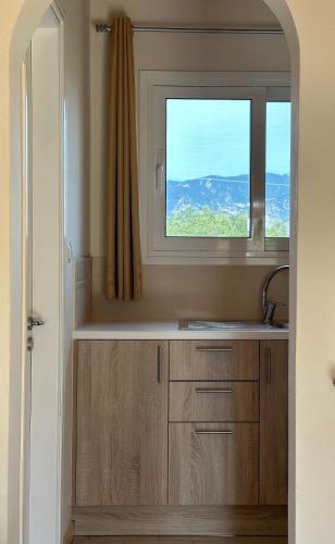 a kitchen with a sink and a window at Aroma Studios in Argostoli