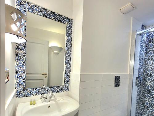 W łazience znajduje się umywalka i lustro. w obiekcie Vicolo 23 House w mieście Atrani