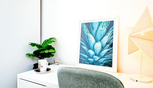 a white desk with a green chair and a picture at Charming London Home, Opp Arnos Grove Underground Station, Parking in New Southgate