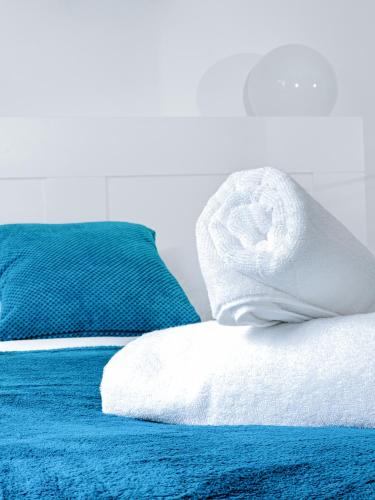 a blue bed with a white towel on it at Charming London Home, Opp Arnos Grove Underground Station, Parking in New Southgate