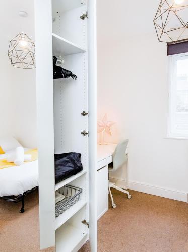 a bedroom with a desk and a closet at Charming London Home, Opp Arnos Grove Underground Station, Parking in New Southgate