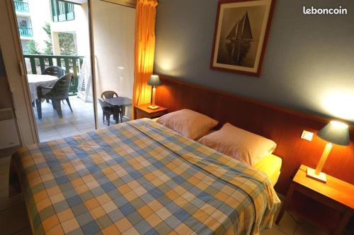 une chambre avec un lit et un balcon avec une table dans l'établissement T2, 2 étoiles, 5 couchages, piscine, Carcans Maubuisson proche Lacanau, à Carcans