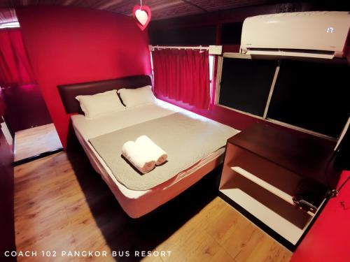 a small room with a bed in a red room at Pangkor Bus Resort by BESLA in Pangkor