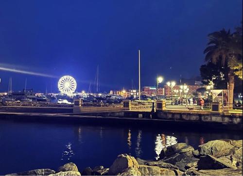 einen Hafen in der Nacht mit einem Riesenrad im Hintergrund in der Unterkunft Sunnyhouse in Santa Margherita Ligure