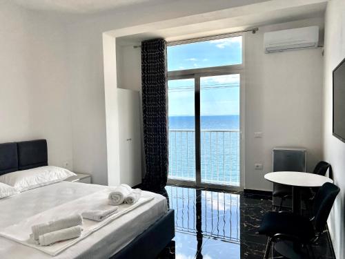 a bedroom with a bed and a view of the ocean at Redi's Seaview Apartments in Sarandë