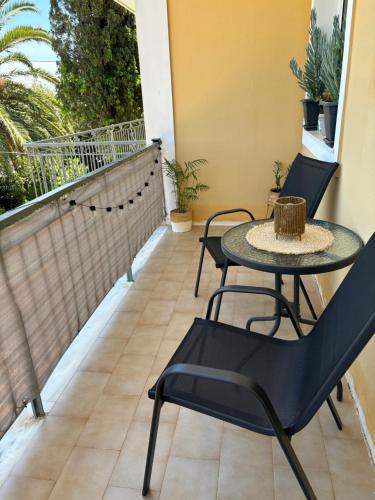 un patio con tavolo e sedie sul balcone. di Myrtilo Apartment a Ambelókipoi