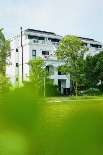 a white building with trees in front of it at Olivia Boutique Hotel in Sanxing