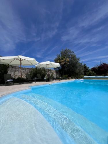 una gran piscina azul con sombrillas en Le Clos Gabrielle en Châtellerault