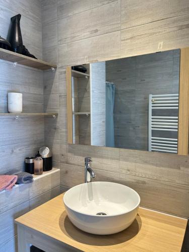 La salle de bains est pourvue d'un lavabo blanc et d'un miroir. dans l'établissement L'ensoleillée Appartement Maison privé Cannes, à Cannes